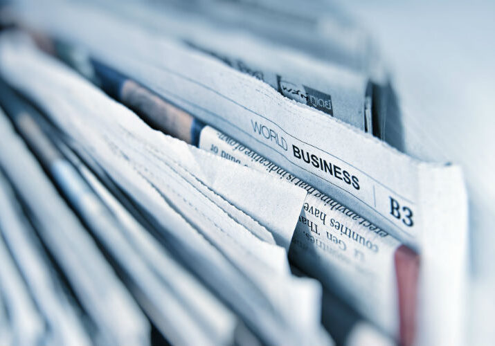 A photo of a stack of newspapers representing the news section of the website